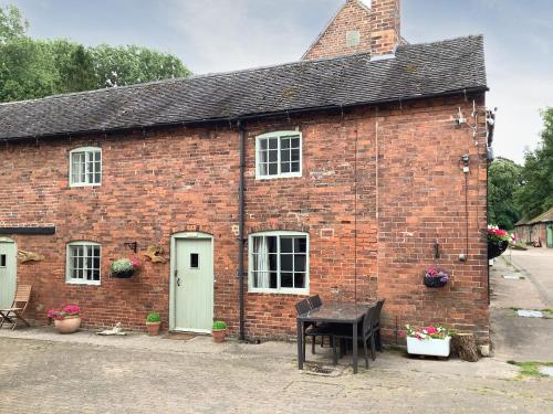 an old brick building with a piano in front of it at Repton Cottage - 25348 in Findern