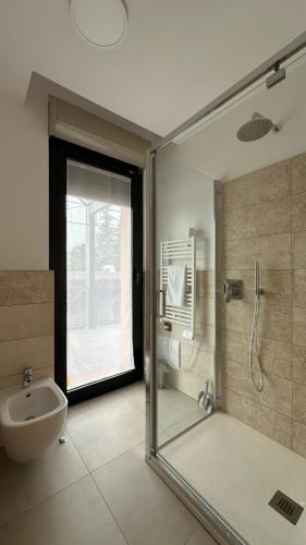 a bathroom with a shower and a toilet and a sink at Foresteria Green House 2 in Seriate