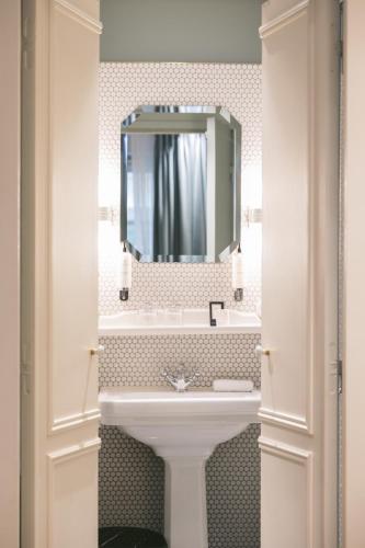 a bathroom with a sink and a mirror at Hotel Bachaumont in Paris