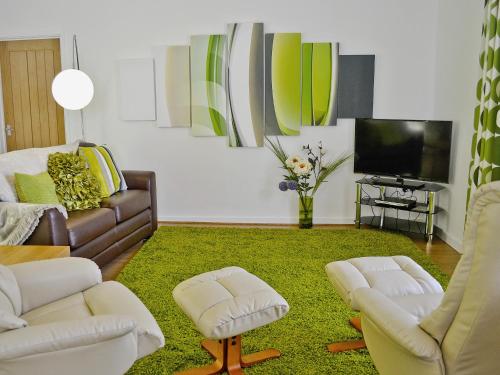 a living room with two couches and a tv at Llwynbedw - 28464 in Cardigan