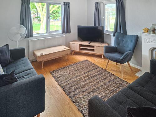a living room with a couch and a tv at Seacroft in Cromer