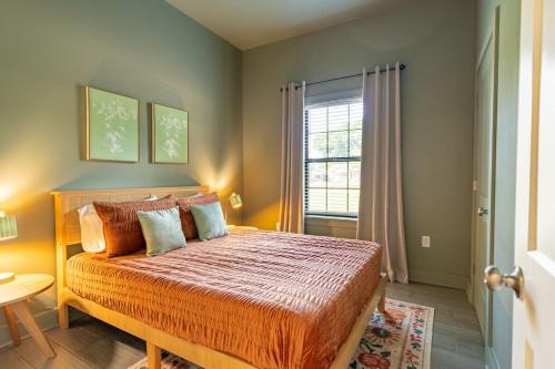a bedroom with a bed with an orange comforter and a window at The Golden Tiger in Baton Rouge