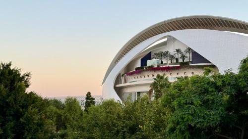 a building with palm trees in front of it at Cosy Rooms Embajador in Valencia