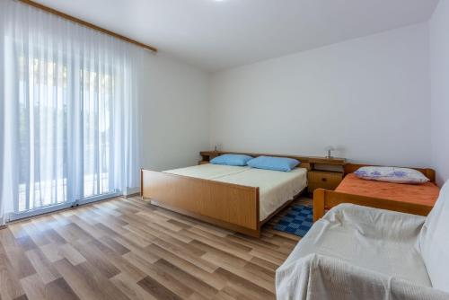 a bedroom with two beds and a large window at Apartment Kreso in Punat