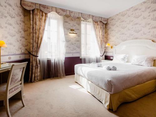 a bedroom with a large white bed and windows at Mercure Moulins Centre Hôtel de Paris in Moulins