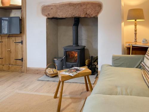 a living room with a wood stove at Smardale Cottage in Crosby Garrett