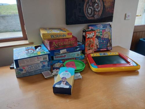 a table with a pile of childrens games and books at Oaktree Manor in Castlewellan