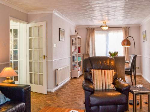 a living room with a leather chair and a table at The Sandpiper in Filey