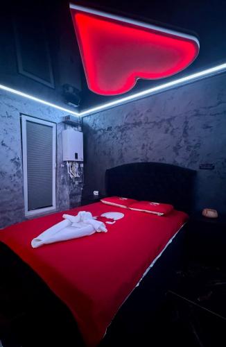 Pokój z czerwonym łóżkiem i czerwonym kocem w obiekcie Love & Jacuzzi w Bukareszcie