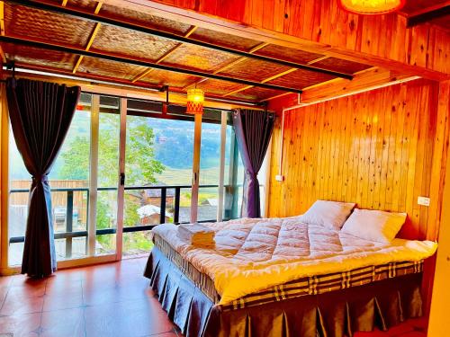 a bedroom with a bed and a large window at Sky View Homestay in Tả Van