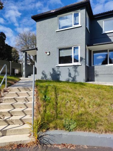 ein graues Haus mit einem Weg davor in der Unterkunft Direct Travel Stays in Cork