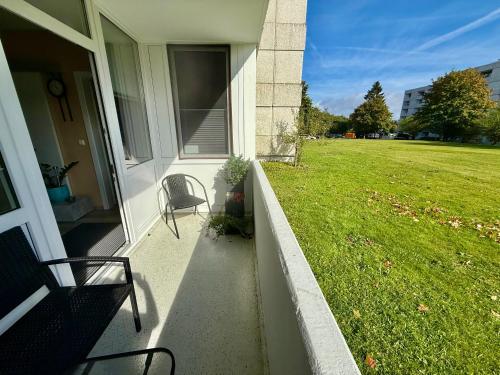 a porch of a house with a chair and a lawn at Moderne und komfortable Appartements im Ferienpark Hahnenklee in Hahnenklee-Bockswiese