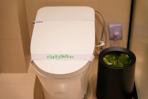 a bathroom with a toilet and a trash can at Lu Ming Beiyuan Xi'an Zhongdu Drum Tower City Wall Store in Xi'an