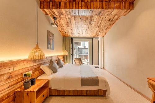 a bedroom with a large bed with a wooden ceiling at Lu Ming Beiyuan Xi'an Zhongdu Drum Tower City Wall Store in Xi'an