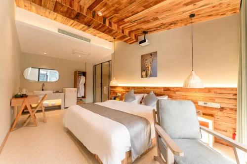 a bedroom with a bed and a desk and a bathroom at Lu Ming Beiyuan Xi'an Zhongdu Drum Tower City Wall Store in Xi'an