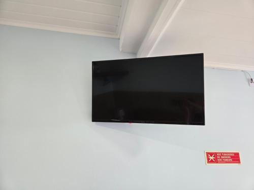 a flat screen tv hanging on a wall at Rainha do Mar AL 3436 in Fontinhas