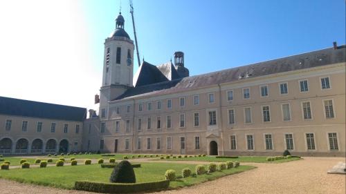 a large building with a clock tower on top of it at Le Relais Cicero in La Flèche