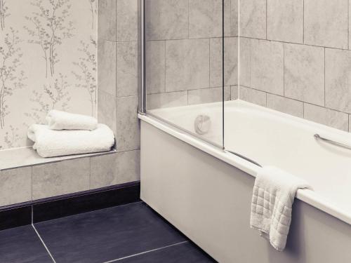 a bathroom with a shower and a bath tub at Mercure Thame Lambert Hotel in Chinnor