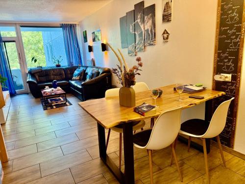 a living room with a wooden table and chairs at Moderne und komfortable Appartements im Ferienpark Hahnenklee in Hahnenklee-Bockswiese