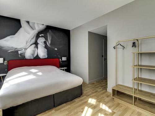 a bedroom with a bed and a painting on the wall at Ibis Styles Toulouse Capitole in Toulouse