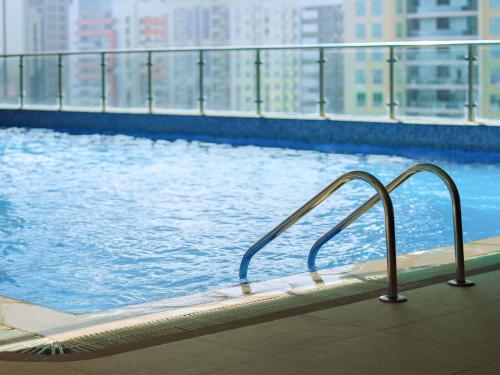 a swimming pool with a view of a city at Mercure Dubai Barsha Heights Hotel Suites And Apartments in Dubai