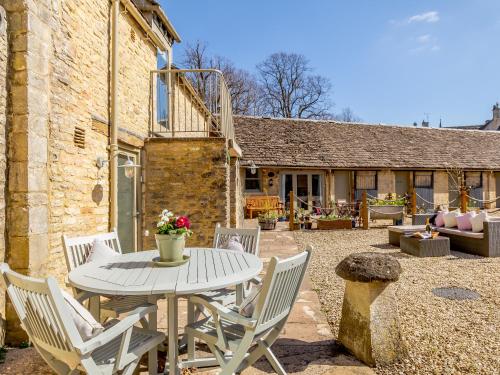a patio with a white table and chairs at Wool Loft in Kemble