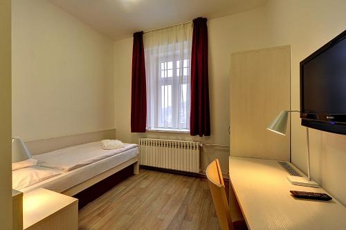 a small room with a bed and a window at Apartmánový komplex Dagmar in Jáchymov