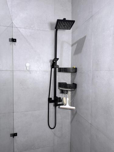 a shower with a black shower head in a bathroom at Jay Jay Homes in Kampala