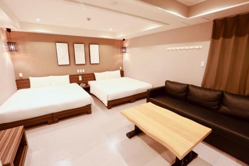 a living room with two beds and a couch at Hotel 88 Shinsaibashi in Osaka