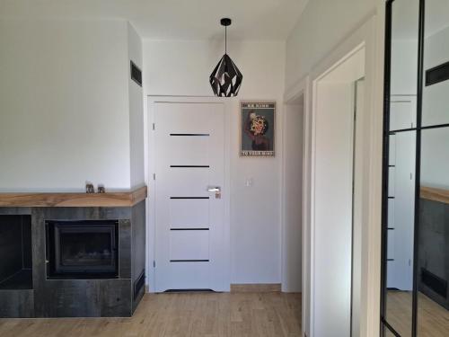 a hallway with a white door and a fireplace at Domek wśród Jabłonek in Łoniów