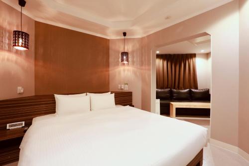 a bedroom with a white bed and a couch at Hotel 88 Shinsaibashi in Osaka