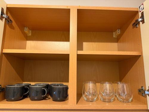 una mensola in legno con occhiali e altri oggetti in vetro di Cosy and Chic Appartement moderne proche gare a Mantes-la-Jolie