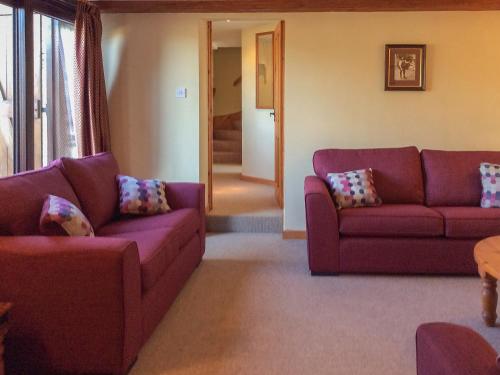 a living room with two purple couches and a table at The Pump House in Hawkesbury