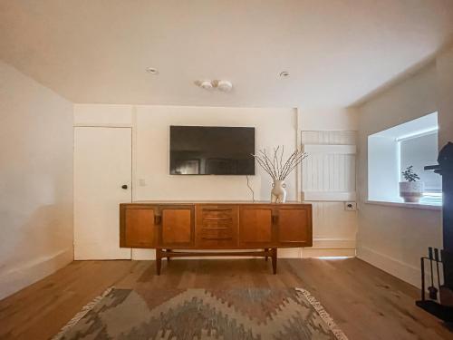 a living room with a flat screen tv on the wall at Fonseca Cottage in Aberfeldy