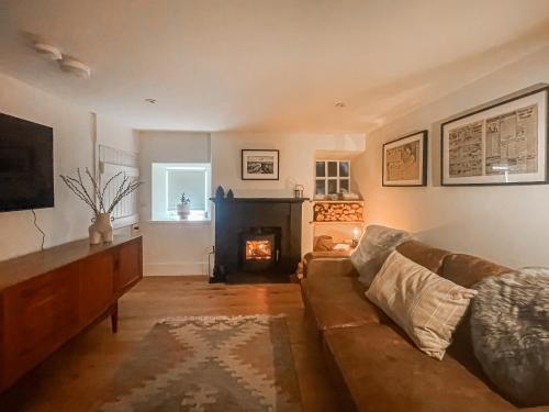 a living room with a couch and a fireplace at Fonseca Cottage in Aberfeldy