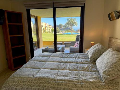 MAITENCILLO VISTA BOSQUE y MAR في مايتنسيلو: غرفة نوم بسرير كبير مع نافذة كبيرة