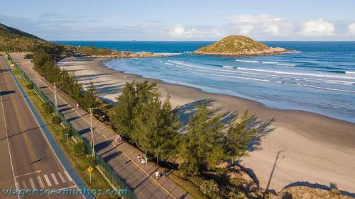 an aerial view of a beach with trees and the ocean at Casa Laranja Imbituba in Imbituba