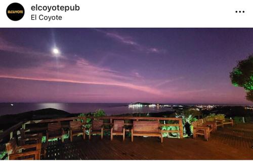 a group of chairs sitting on a deck at night at Casa Laranja Imbituba in Imbituba