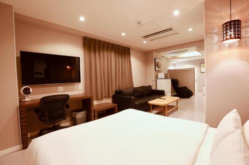 a hotel room with a bed and a living room at Hotel 88 Shinsaibashi in Osaka