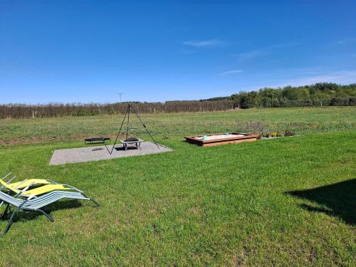a park with a swing and a playground in a field at Domek wśród Jabłonek in Łoniów