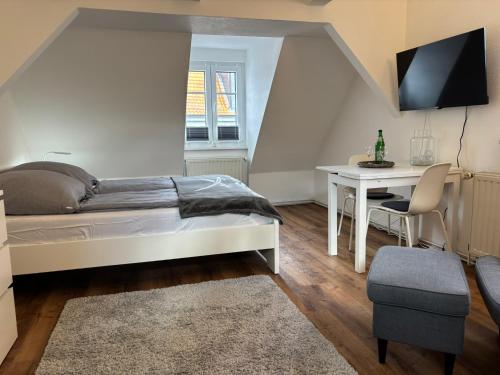 a bedroom with a bed and a table and a desk at Ferienwohnung Mitten drin Bad Arolsen in Bad Arolsen