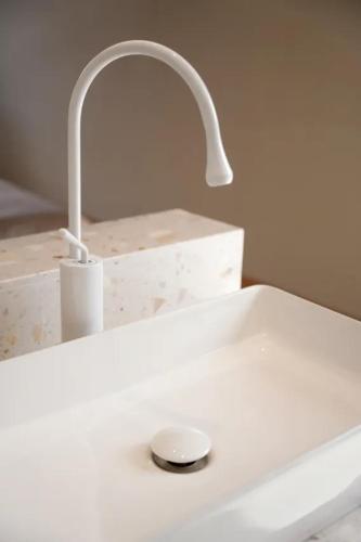 a white bathroom sink with a faucet at Lu Ming Beiyuan Xi'an Zhongdu Drum Tower City Wall Store in Xi'an
