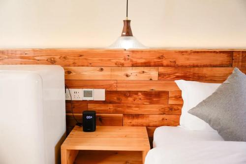 a bedroom with a wooden headboard with a bed and a table at Lu Ming Beiyuan Xi'an Zhongdu Drum Tower City Wall Store in Xi'an