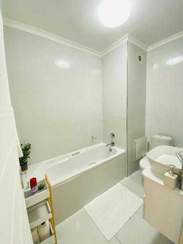 a white bathroom with a tub and a sink at Pure Bliss Ocean Apartment in Kingsborough