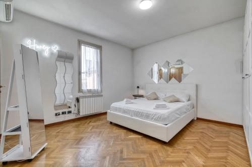 a white bedroom with a bed and a mirror at Honey Terminal in Bologna