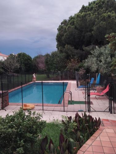 a swimming pool with a fence around it at Maison de vacances avec piscine et jardin in Bompas