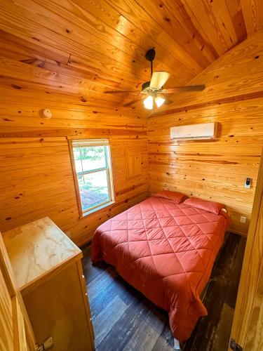 a bedroom with a bed in a wooden cabin at Bonanza Camping Resort in Wisconsin Dells
