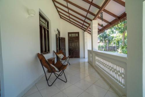 a porch with two chairs on a house at Bird Of Paradise - Ahangama Villa in Ahangama