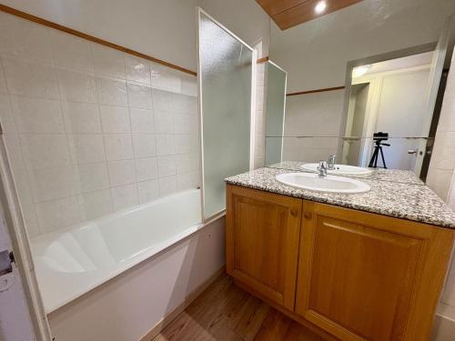 un bagno con lavandino e vasca da bagno di Appartement cosy T2 Duplex a Bolquere Pyrenees 2000