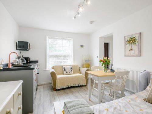 a kitchen and living room with a table and chairs at The Gardens in Santon